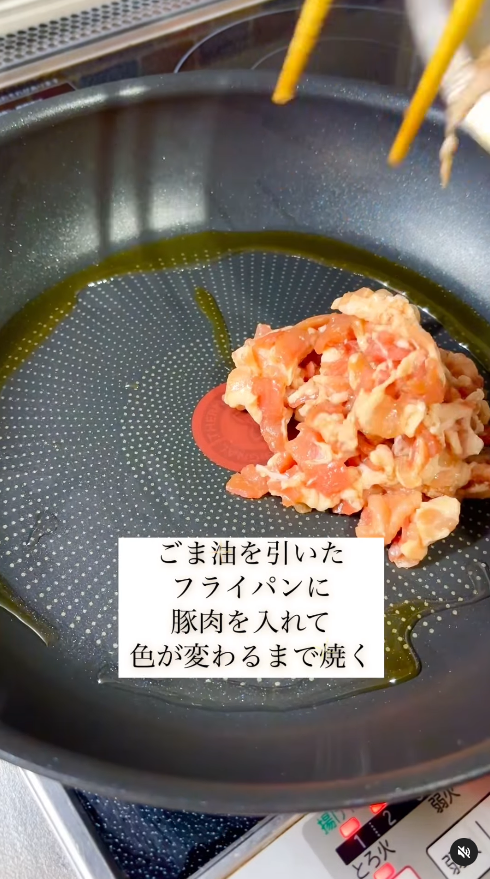 フライパンにごま油を熱し、豚肉を炒める