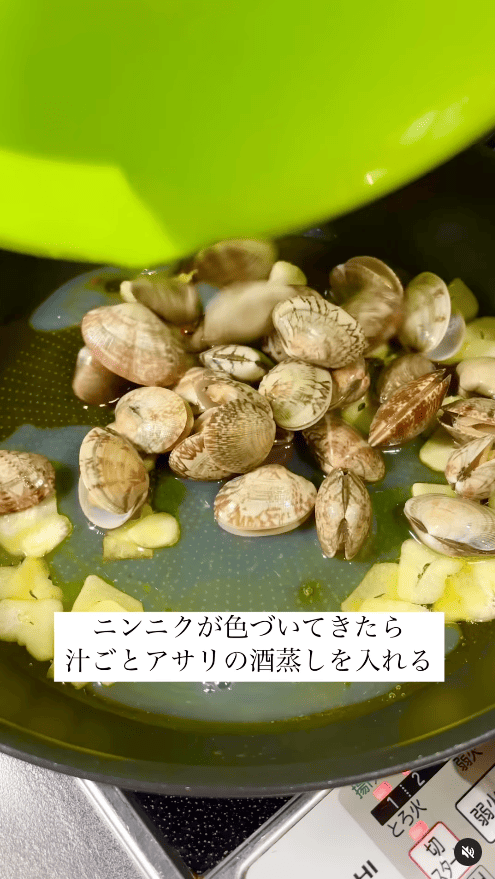 ニンニクが色付いてきたら、汁ごとアサリをフライパンへ