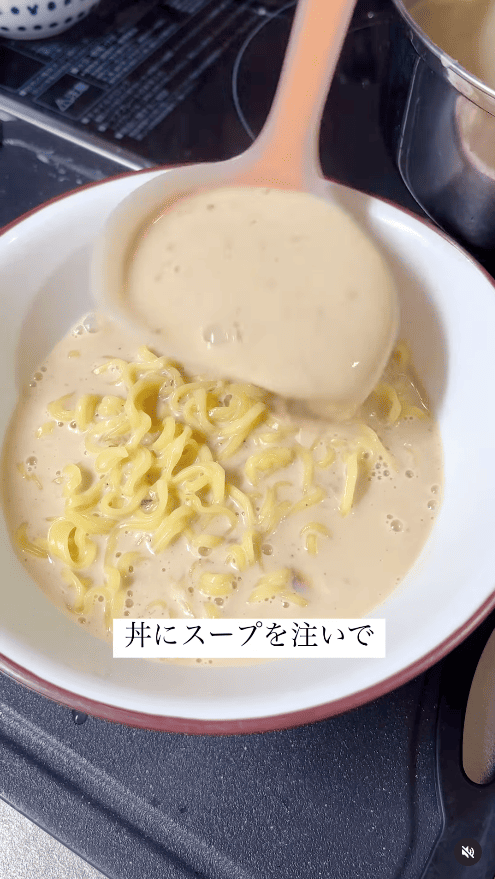 麺の丼にスープを注ぐ