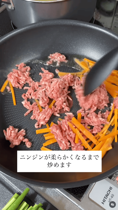 フライパンでサラダ油を熱し、ニンジン（細切り）と豚ひき肉を炒める